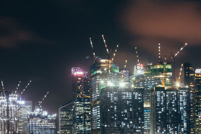 Illuminated cityscape against sky at night