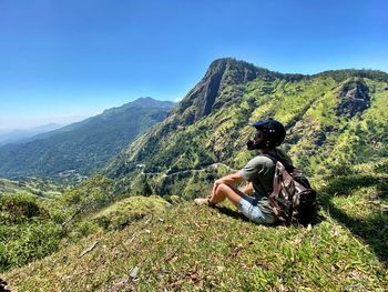 Man wearing sunglasses on mountain against sky