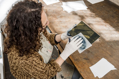 Female artist preparing a plate for an art print.