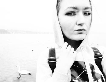 Close-up portrait of young woman holding water