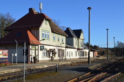 Railroad tracks by buildings against sky