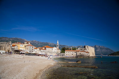 Buildings in town against clear blue sky