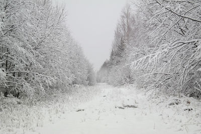 Snow covered field against clear sky