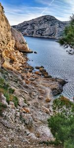 Scenic view of rocks by lake against sky