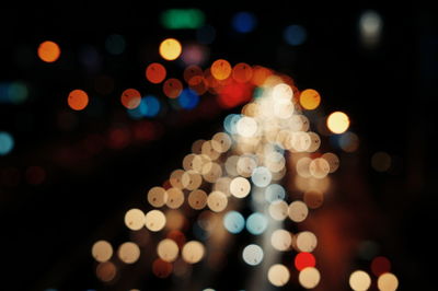 Defocused image of vehicle headlights on street at night