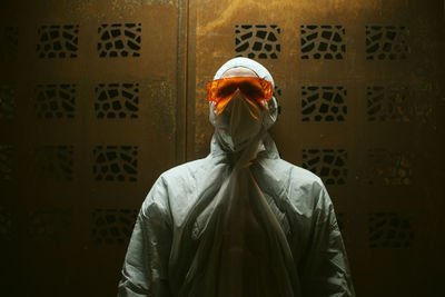 Portrait of man wearing protective workwear against wall