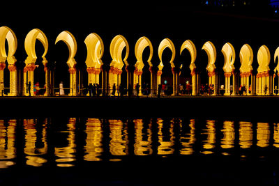 Reflection of illuminated building in lake at night