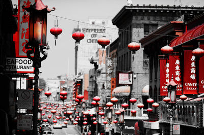 Red lanterns hanging amidst buildings in city
