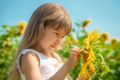 Cute girl touching sunflower