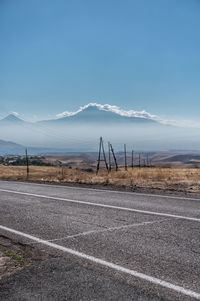 Road by field against sky