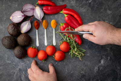 Cropped hand of woman holding fruits on table