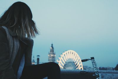 Woman in city against sky