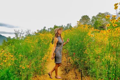 Woman standing on field against sky