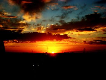 Silhouette landscape against dramatic sky during sunset