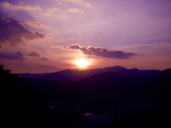 Scenic view of silhouette mountains against sky at sunset