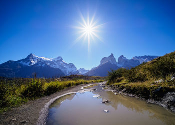 Scenic view of lake and mountains against blue sky