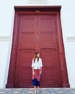 Woman standing against closed door of building