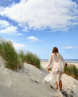 Beach girl walking in dune landscape