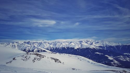 Scenic view of snowcapped mountains against blue sky