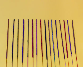 Close-up of multi colored pencils against wall