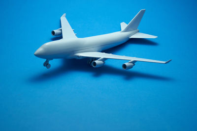 Close-up of airplane over blue background
