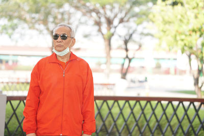 Portrait of man wearing sunglasses standing against plants