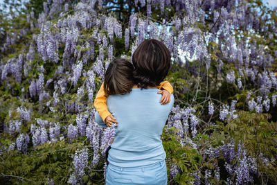 Rear view of mother and a child holding each other