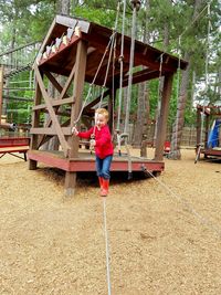 Full length of cute boy walking on rope at playground