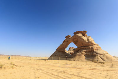 View of sculpture on desert against clear blue sky