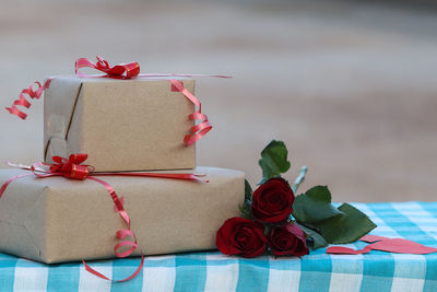 Close-up of gift boxes and roses on table