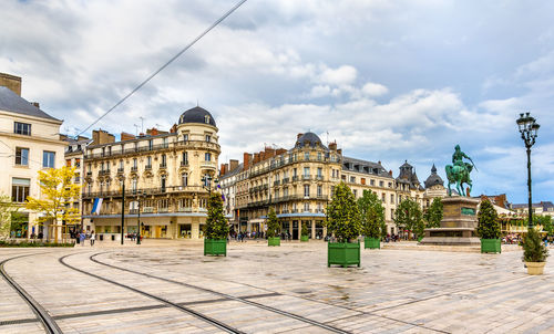 Buildings in city against cloudy sky