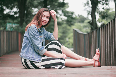 Portrait of smiling young woman sitting outdoors