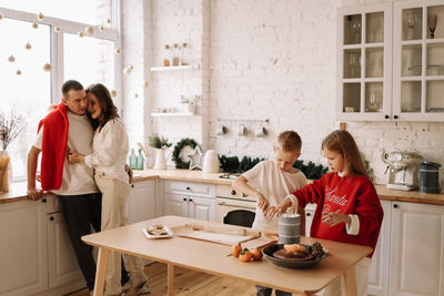 Family with children having fun and laughing while preparing for the christmas holiday in kitchen