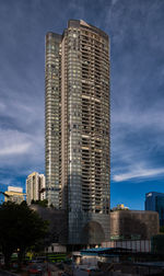 Low angle view of modern buildings against cloudy sky