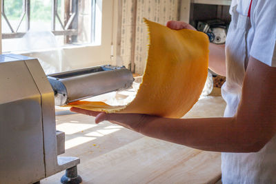 Midsection of man kneading dough