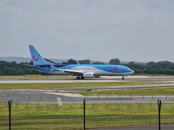 Airplane on runway against sky