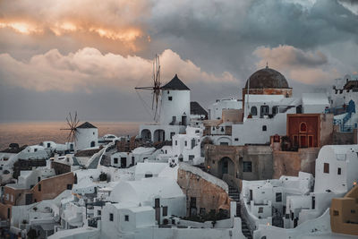 Buildings in city against cloudy sky