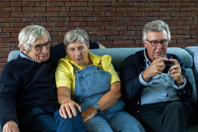 Friends sitting on sofa at home