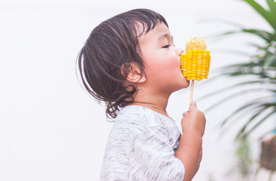Young woman holding ice cream against white background