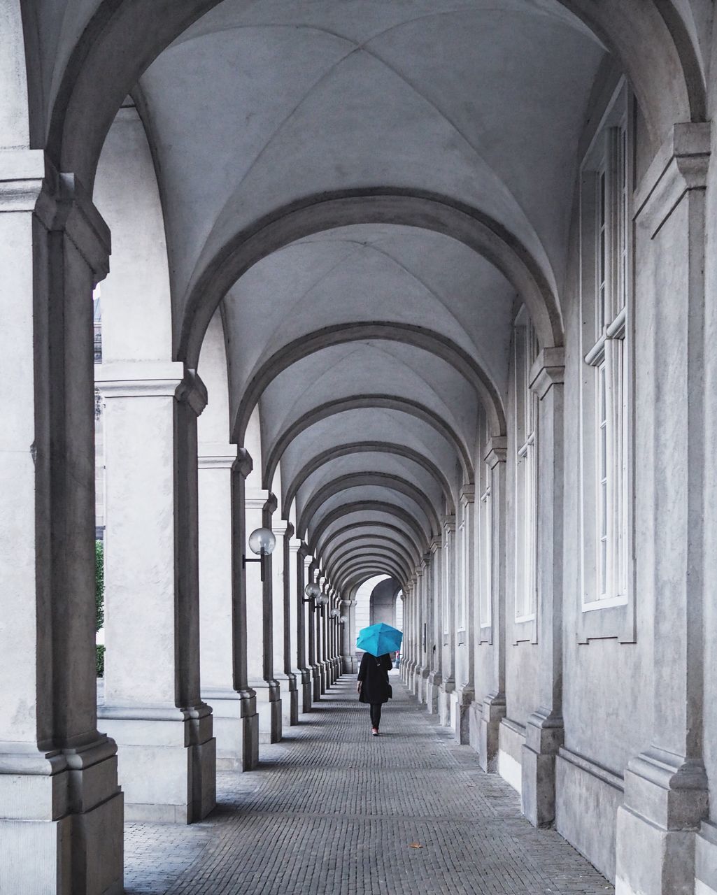 REAR VIEW OF PEOPLE WALKING IN CORRIDOR