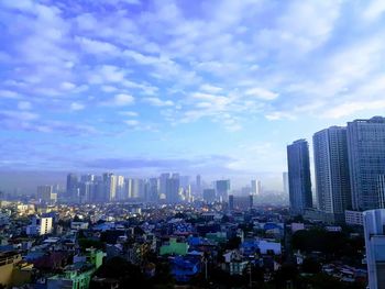 Aerial view of buildings in city against sky