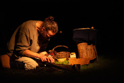 Man sitting by fire against black background