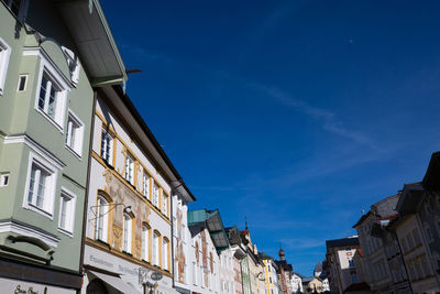 Low angle view of buildings in town against blue sky