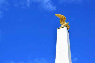 Low angle view of statue against blue sky