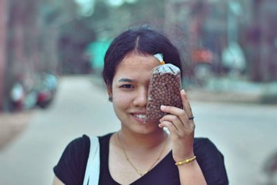 Close-up of young woman holding packet
