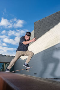 Low angle view of young woman exercising against sky