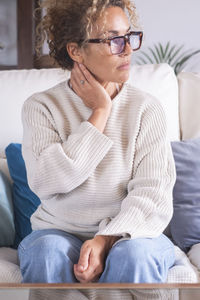 Young woman sitting on sofa at home