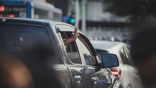 Cropped hand of man gesturing through car window