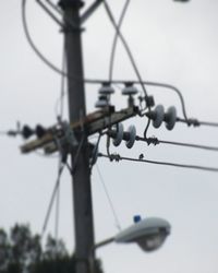 Low angle view of telephone pole against sky