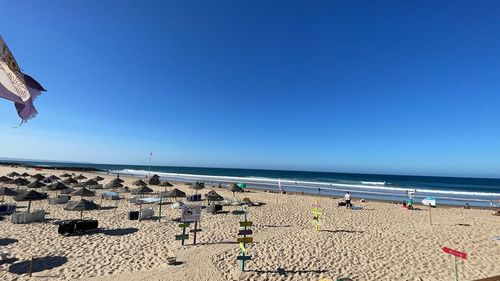 Scenic view of beach against clear blue sky
